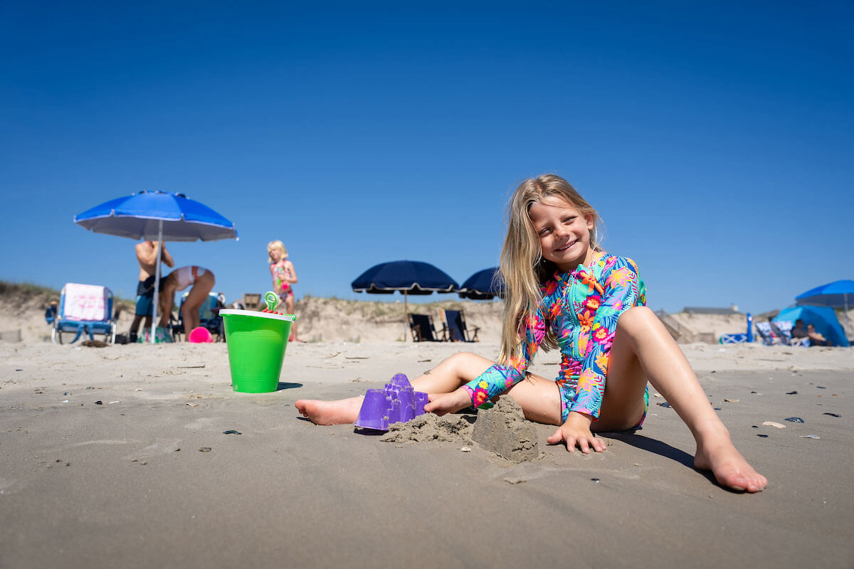 family on beach playing in sand